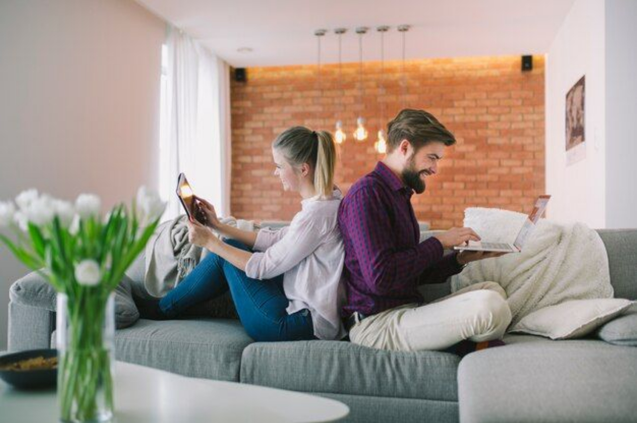 Couple comfortably researching mortgage options online in their cozy UK home.